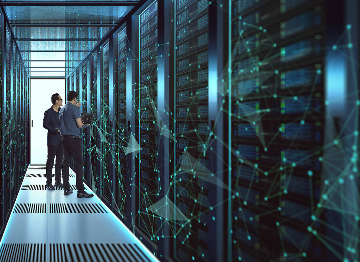 Two men standing in a server room doing hardware checkups