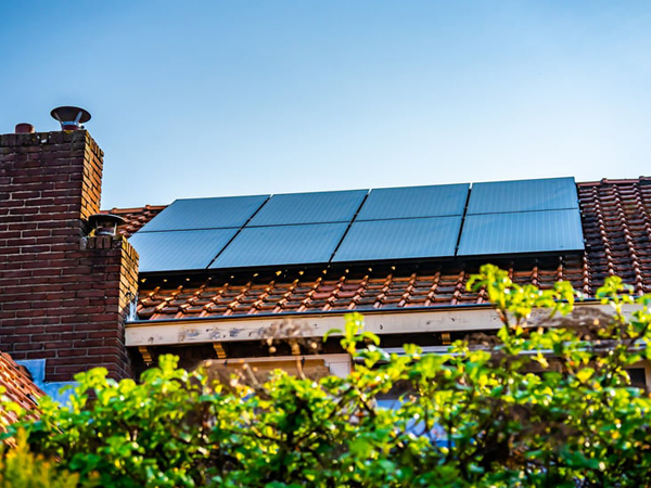 Zonnepanelen op een dak met blauwe lucht op de achtergrond