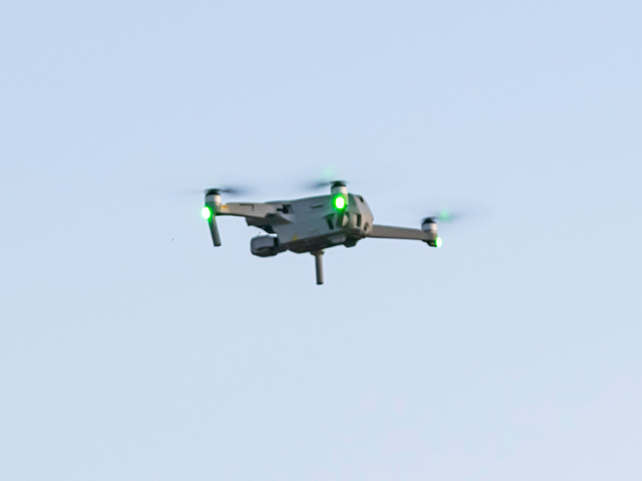 Drone flies with blue sky in background